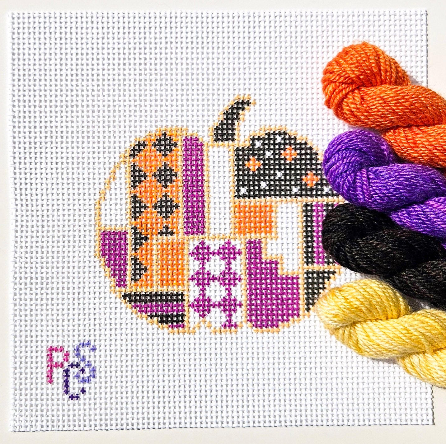 Hand-painted geometric pumpkin needlepoint canvas designed for finishing as a Halloween ornament kitted with Dinky Dyes