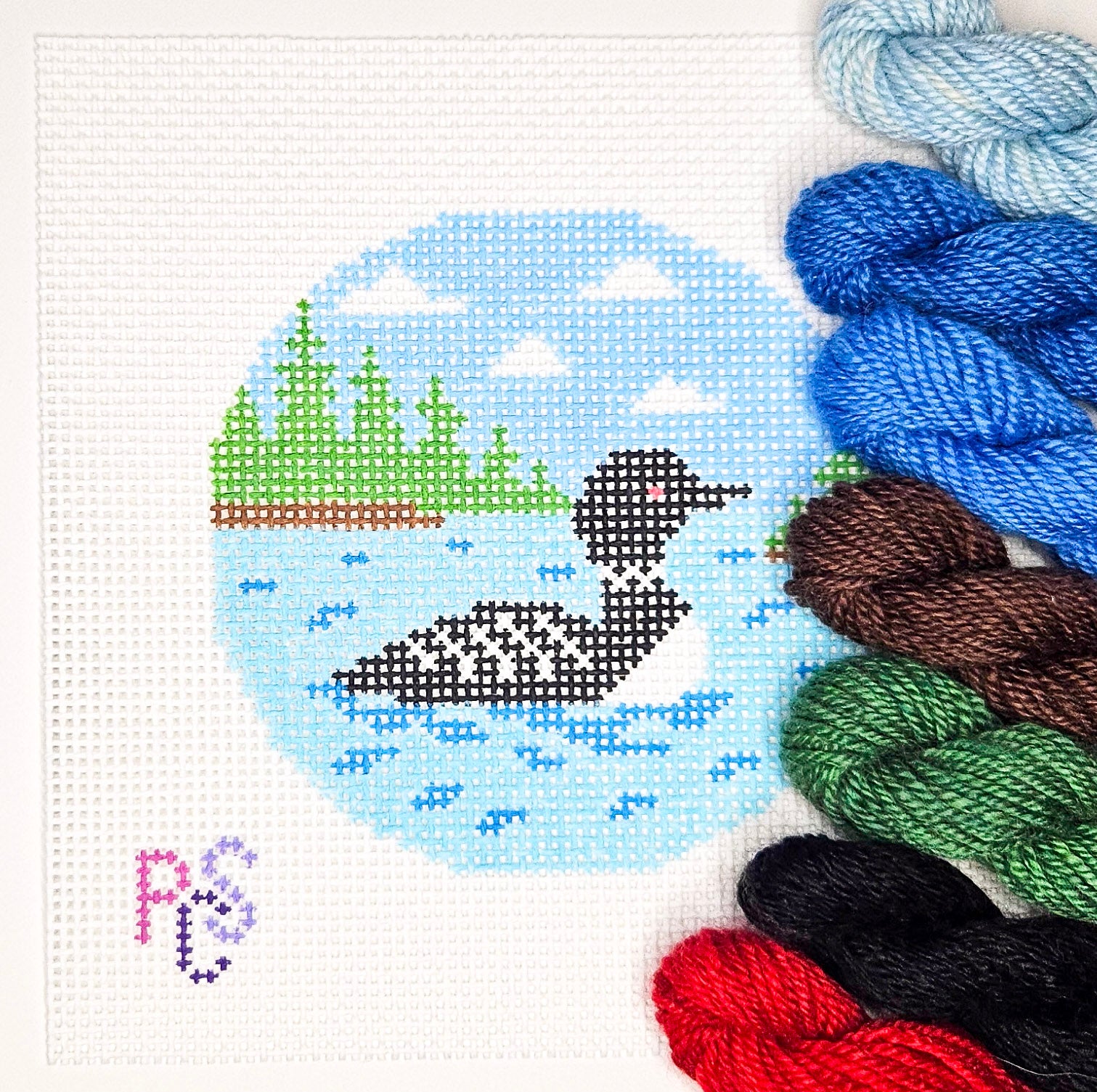 Canadian loon needlepoint canvas with blue lake, evergreen forest and open sky on 13 mesh canvas kited with DinkyDyes