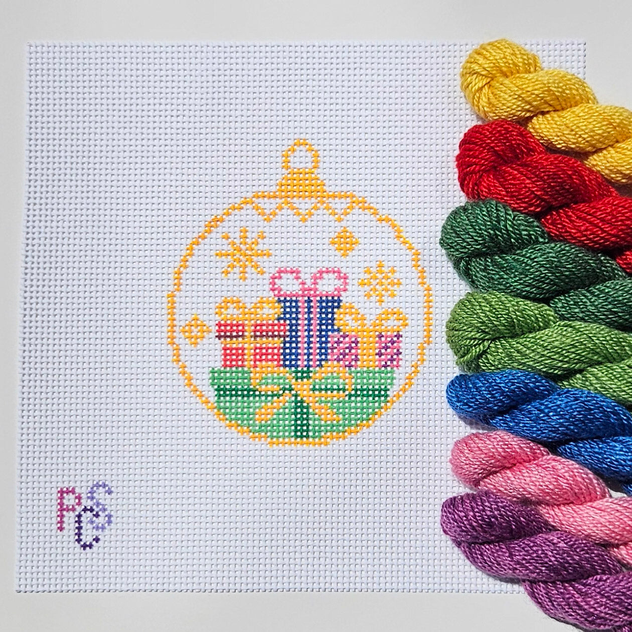 Hand-painted Christmas ornament needlepoint canvas featuring colorful wrapped gifts inside a classic ornament design on premium 13 Mesh Mono Canvas Dinky Dyes