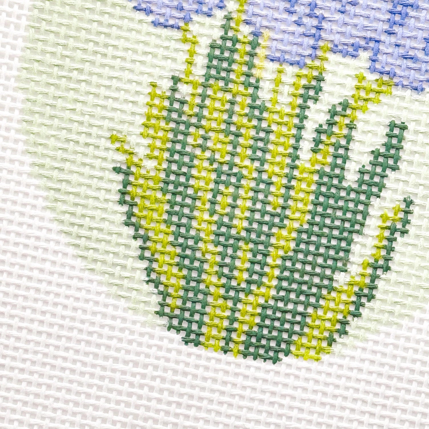 Close-up of needlepoint tulip design on fabric