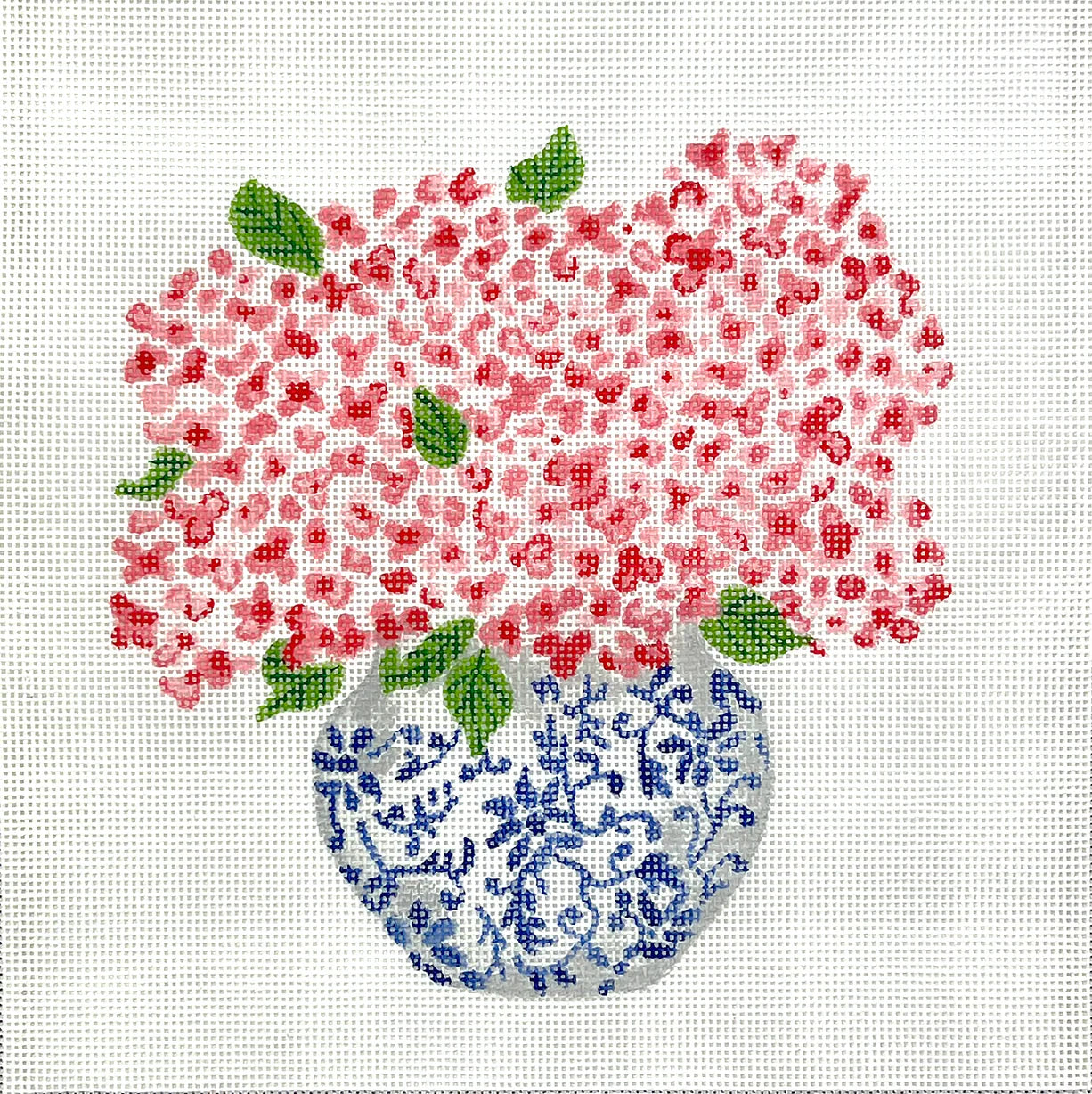 Decorative needlepoint of pink flowers in a blue and white vase on a white background
