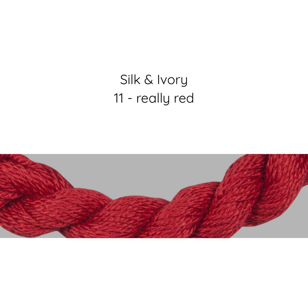 Red yarn skein labeled 'Silk & Ivory 11 - really red' on a gray background