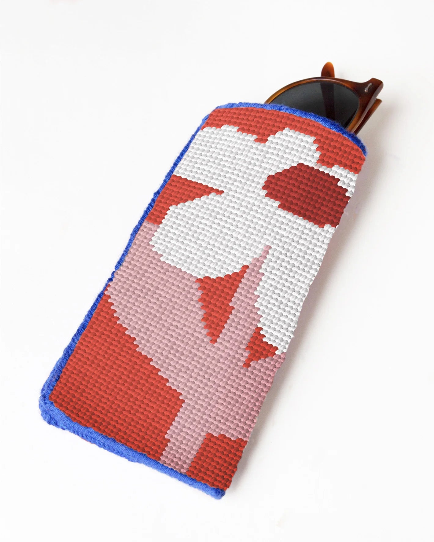 Needlepoint glasses case with a red and white design on a white background